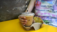 Black and white striped paper straw in iced coffee cup within lifestyle cafe photograph