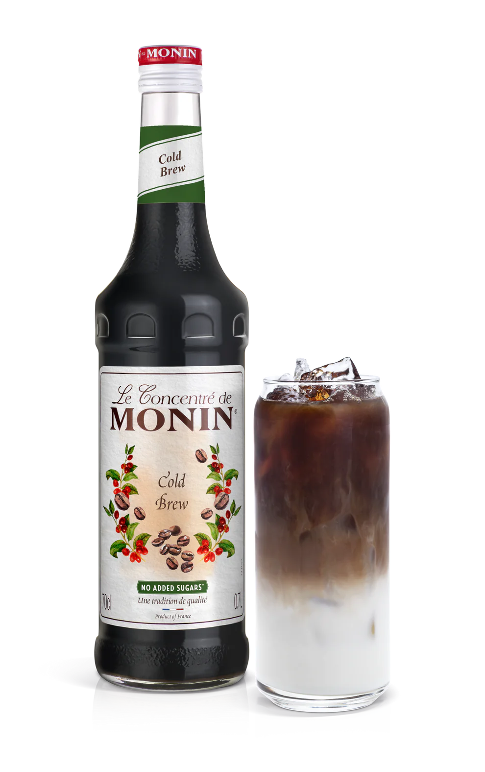 A bottle of Monin Cold Brew Concentrate next to a glass filled with ice and a serving of the concentrate, showcasing a creamy brown liquid.