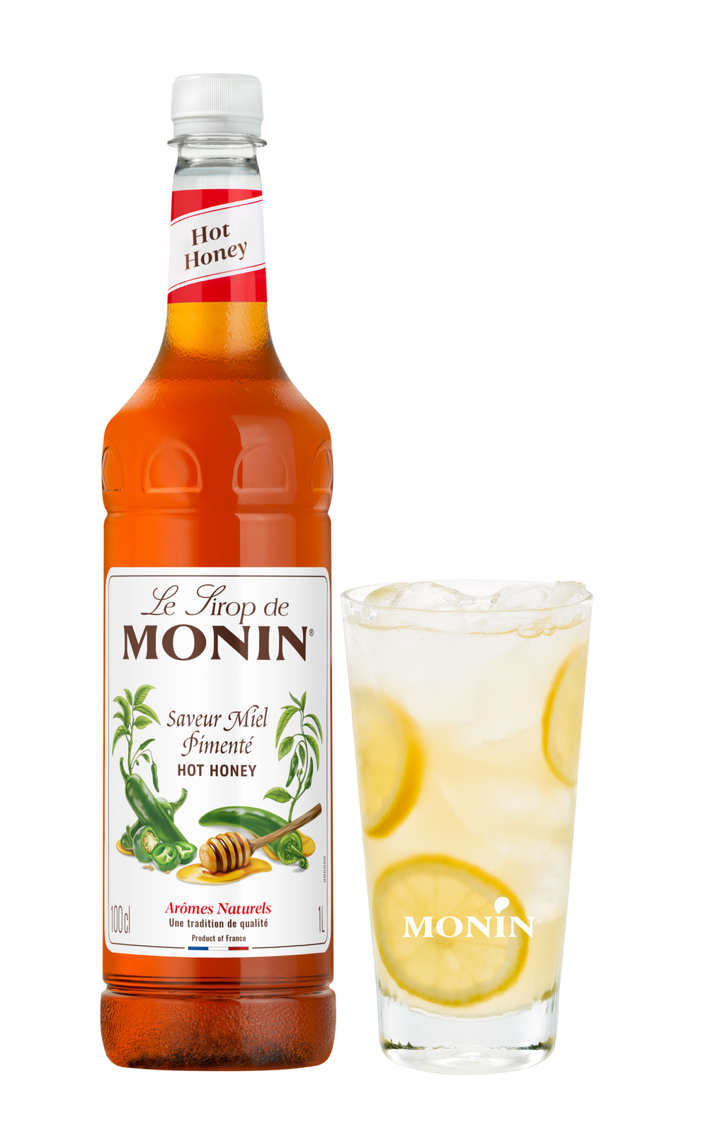 Monin Hot Honey syrup bottle with a glass of lemonade on a white background