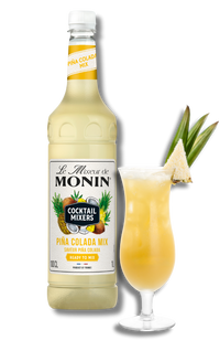 Monin Pina Colada Mix bottle with a glass of cocktail and pineapple garnish on a white background