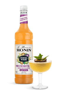 Monin cocktail mixer bottle with a cocktail garnished with a mint leaf on a white background