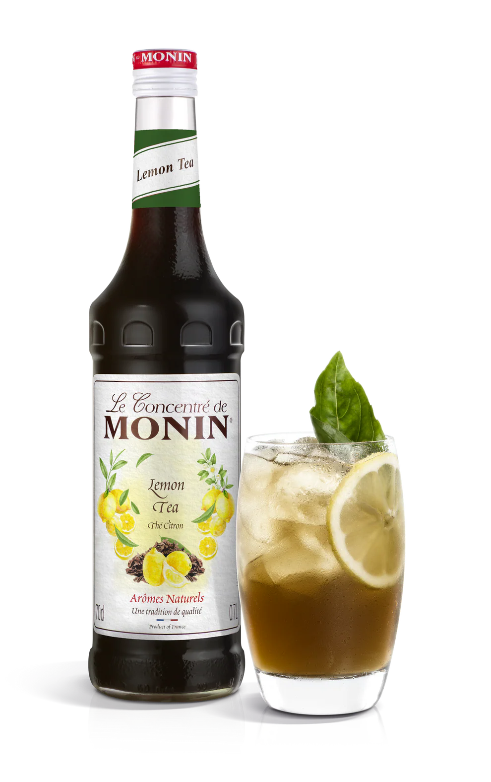 Monin Lemon Tea syrup bottle with a glass of lemon tea on a white background