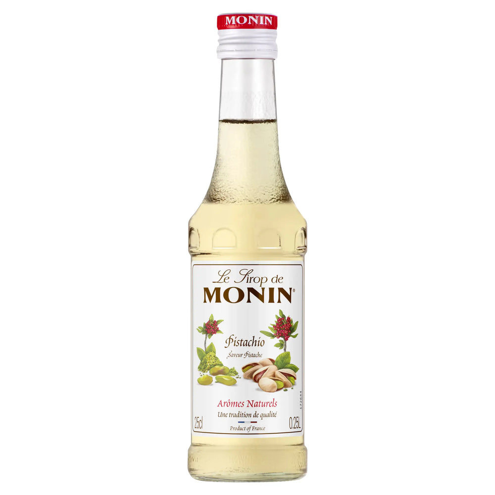 Monin pistachio syrup bottle close up with red cap and label showing pistachio nuts illustration for coffee syrups