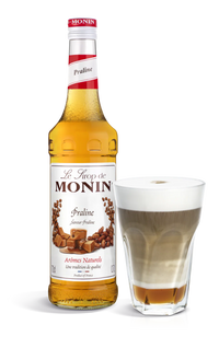 Monin Praline syrup bottle with a glass of coffee.