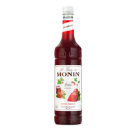 A bottle of Monin Strawberry Syrup with a label showing a picture of fresh strawberries and the name of the syrup variety.