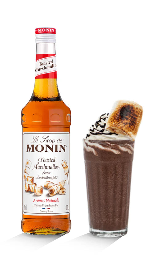 Monin Toasted Marshmallow syrup bottle next to a dessert with marshmallow fluff and a graham cracker.