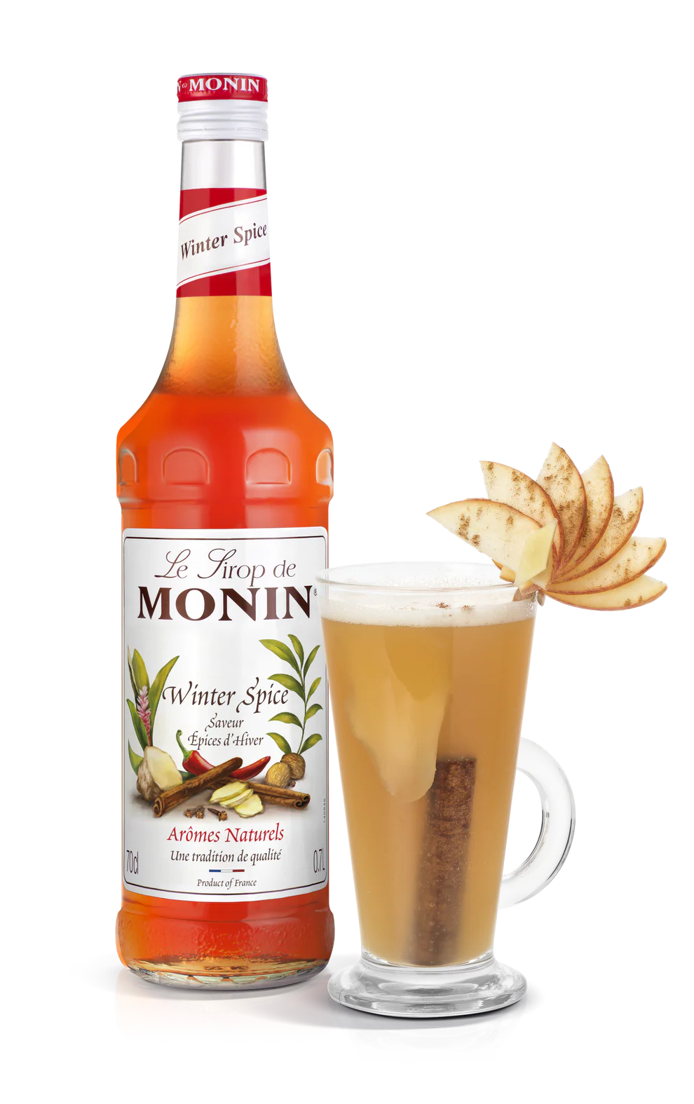 Monin Winter Spice syrup bottle with a glass of hot beverage garnished with apple slices on a white background