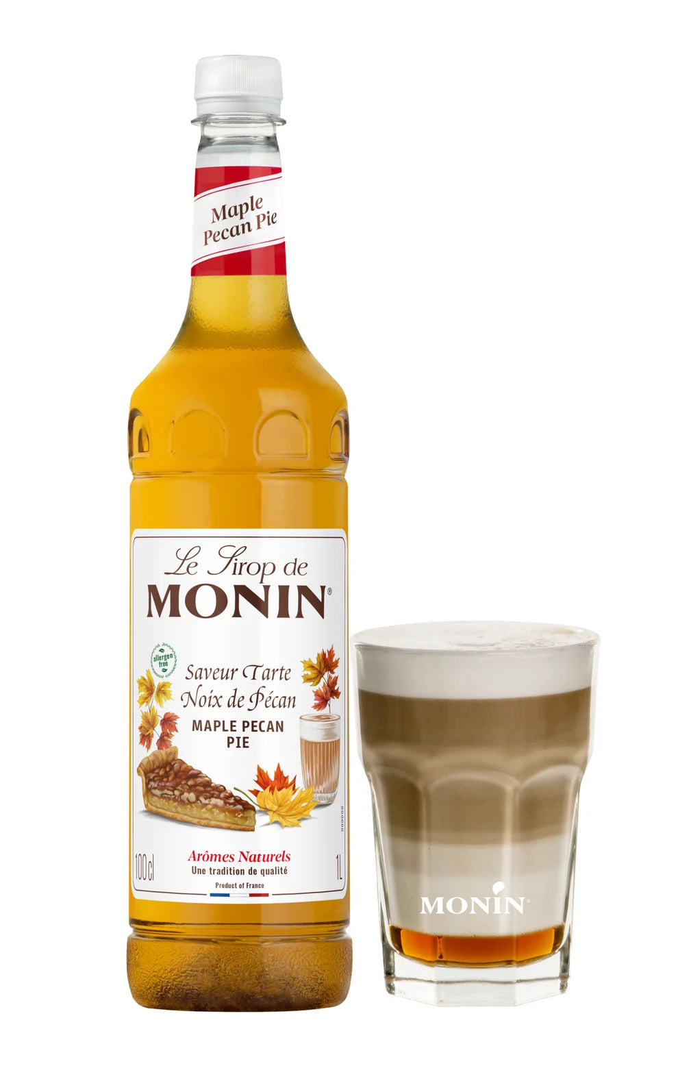 Bottle of Monin Maple Pecan syrup with a glass of coffee on a white background