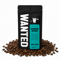 A black stand-up coffee bag labeled WANTED Colombian Supremo whole bean coffee, standing upright on a white background with roasted coffee beans scattered around its base.