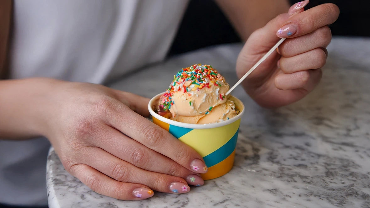 Lifestyle photograph of hands holding colorful patterned 4oz ice cream tub filled with homemade ice cream and sprinkles