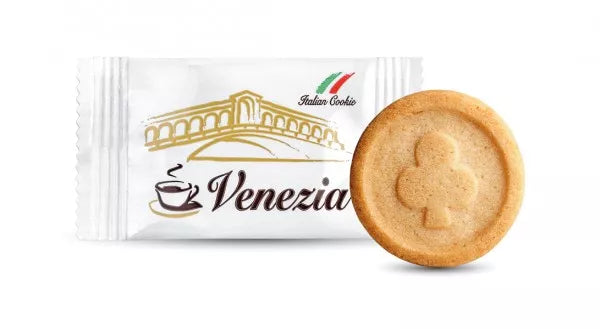 Close-up product photo of Italian Caffè Venezia cookie sachet beside single round biscuit stamped with club suit emblem.