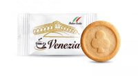 Close-up product photo of Italian Caffè Venezia cookie sachet beside single round biscuit stamped with club suit emblem.