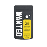 A black stand-up coffee bag with large distressed white 'WANTED' text on the left and a bright yellow label reading 'FRESH ROASTED FRENCH ROAST' and 'WHOLE BEAN' on a clean white background.