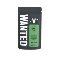 A matte black coffee bag labeled 'WANTED' with a green panel reading 'Fresh Roasted Temple Bar' and 'Whole Bean' below, centered on a plain white background.