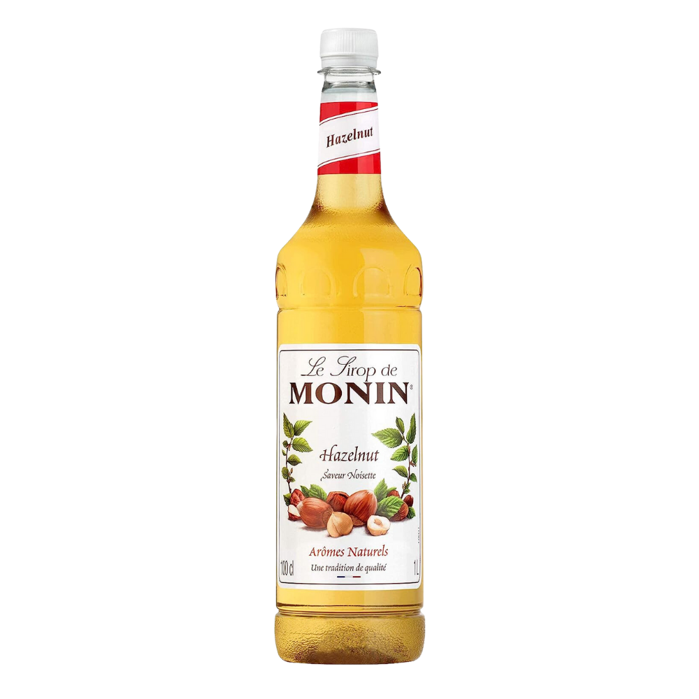 A bottle of Monin Hazelnut Syrup with a label showing the brand name, the word 'Hazelnot' and images of hazelnuts, suggesting the flavor of the syrup.