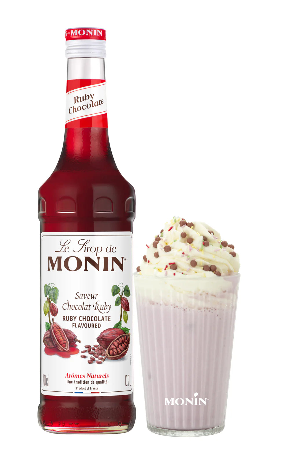 Ruby Chocolate Monin syrup bottle beside ruby hot chocolate drink with whipped cream and sprinkles