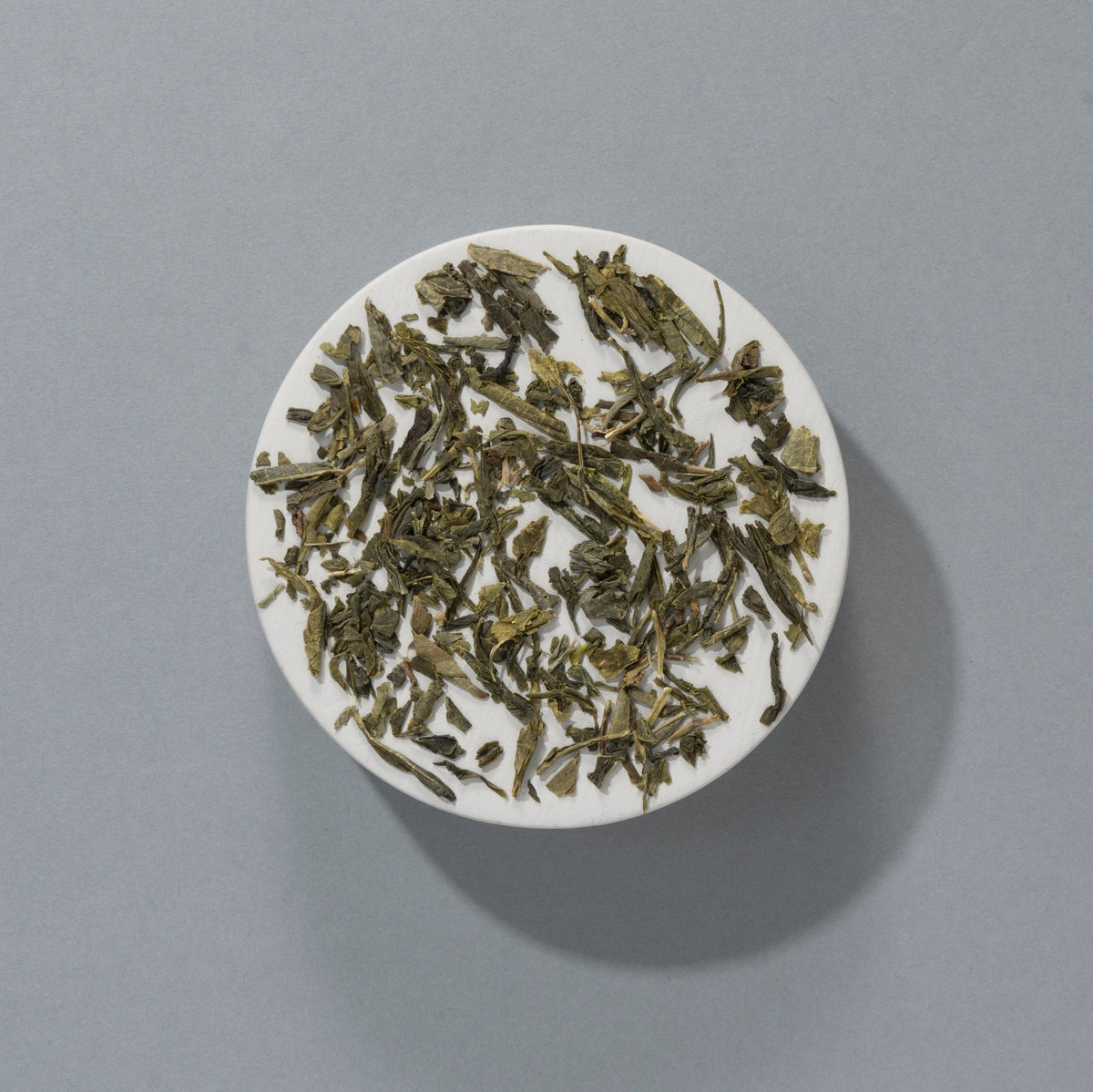 Suki Organic Sencha loose green tea leaves on a white plate